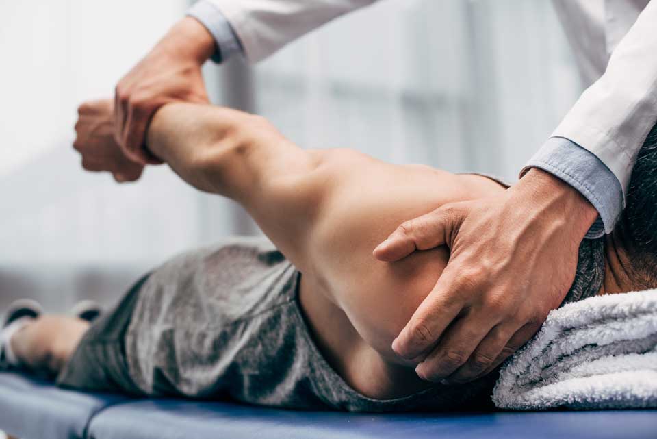 A chiropractor from The Healing Center is treating a patient's arm